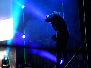 Profesional de Foreground fotografiando desde bastidores la iluminación de un evento